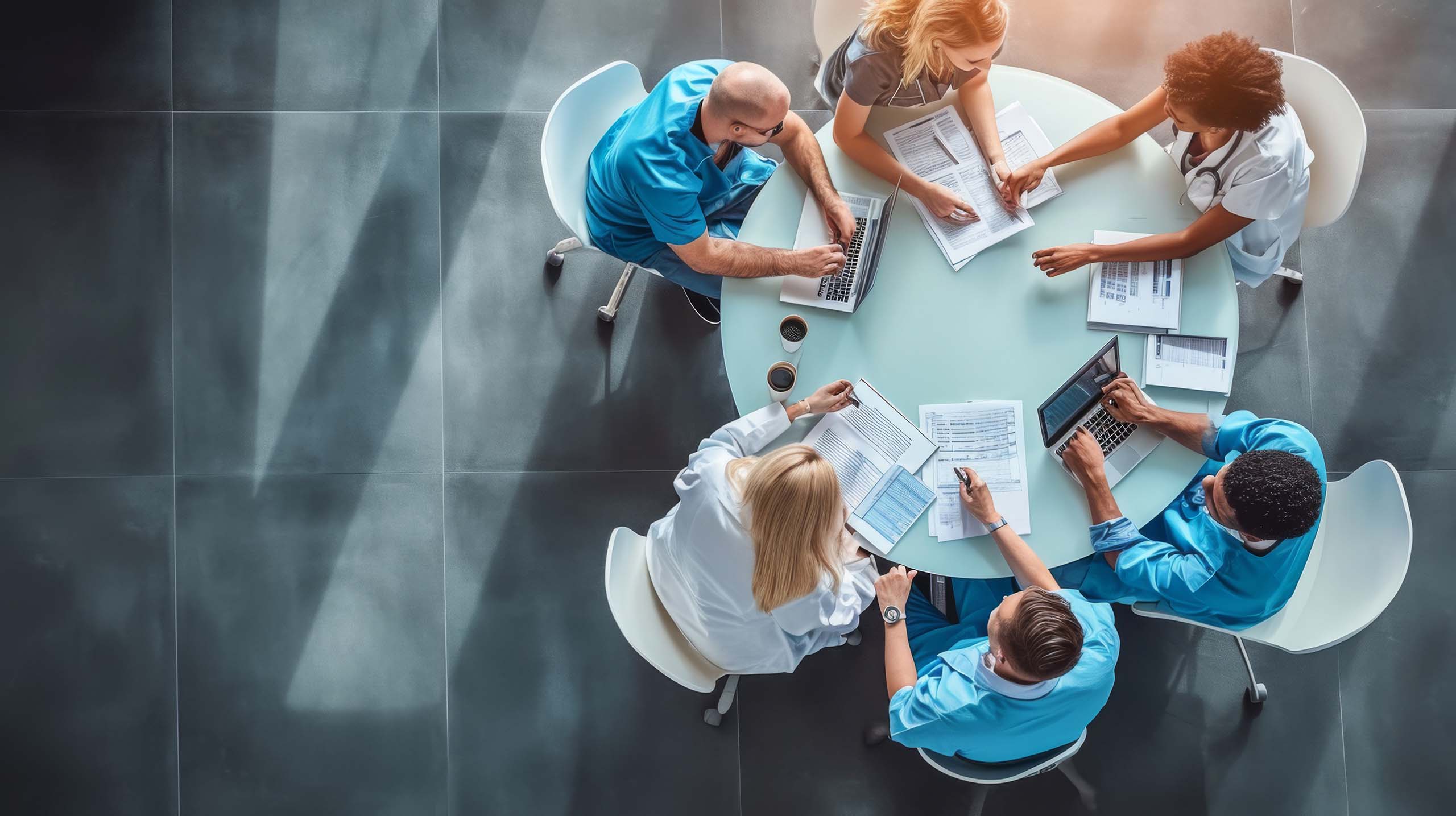 Medical team engaged in a discussion around a round table, viewed from a high angle.