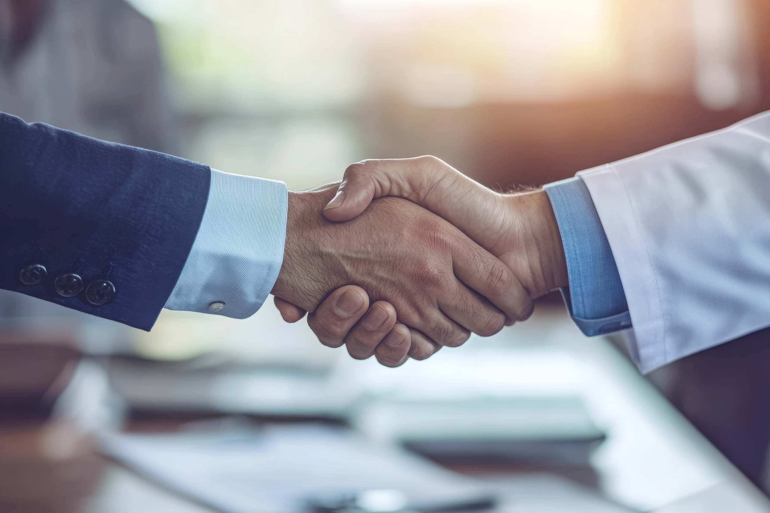 Close-up handshake between doctor and businessman
